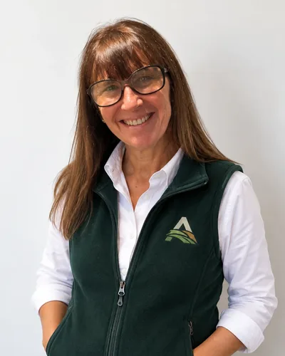 Susana Robles, arquitecta de Altos de San Isidro, sonriendo con el chaleco del barrio